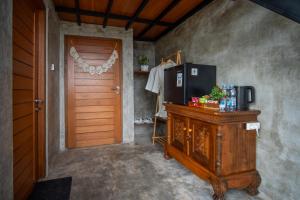 a room with a wooden cabinet with a television and a door at Kintamani Sari Hills in Kintamani