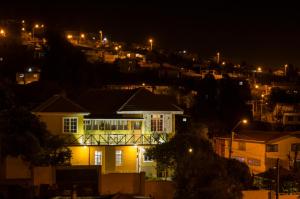 a house with lights on in a city at night at Pontoval B&B in Valparaíso