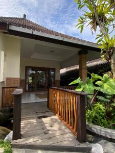 a wooden walkway leading to a house at Dava Guest House Gianyar in Gianyar