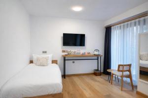 a bedroom with a bed and a desk and a tv at Pastel İstanbul in Istanbul