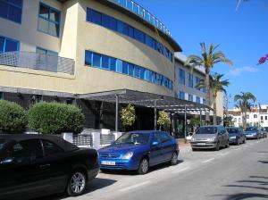 un grupo de coches estacionados frente a un edificio en Hotel Rober Palas en Albir