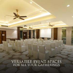 a conference room with white chairs and a ceiling at The Rosefinch Sarovar Portico in Bhīm Tāl