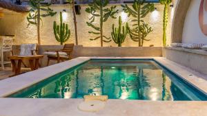 a swimming pool with a cactus wall at Moon Alaçatı adults only in Çeşme