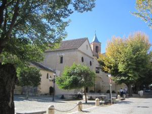 a large stone building with a church in the background at Apartamentos Salmerones in Alhama de Granada