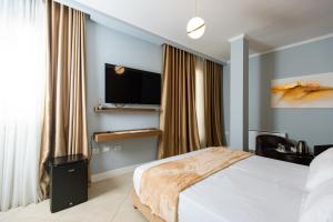 a bedroom with a bed and a flat screen tv at Oxygen Boutique Hotel in Tirana