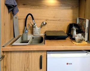 a kitchen counter with a sink in a kitchen at Studio Sunset in Voždivac +17 photos