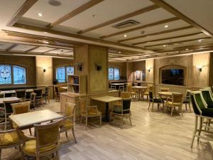 a restaurant with tables and chairs in a room at Büyük Sümela Otel in Macka