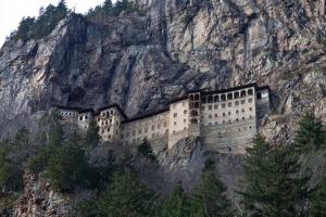 a large building on the side of a mountain at Büyük Sümela Otel in Macka