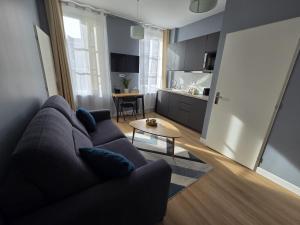 a living room with a couch and a table at G4 - Appartement 2 ch Climatisé Centre Angoulême in Angoulême