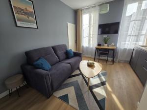 a living room with a couch and a table at G4 - Appartement 2 ch Climatisé Centre Angoulême in Angoulême