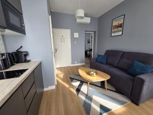 a living room with a couch and a table at G4 - Appartement 2 ch Climatisé Centre Angoulême in Angoulême +3 photos