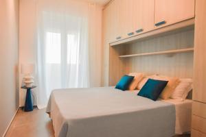 a bedroom with a large white bed with blue pillows at LifeStyle Boutique Apartment in Monopoli