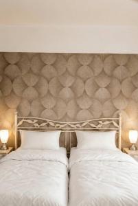 a bed with a headboard with two white pillows at FeWo Jette in Warnemünde