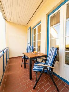 a patio with two chairs and a table on a porch at FeWo Jette in Warnemünde