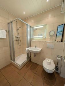 a bathroom with a shower and a toilet and a sink at FeWo Jette in Warnemünde +4 photos