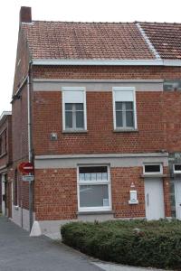 a brick building with two windows and a street at Vakantiewoning Cosy Corner in Ypres