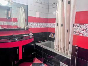 a red and black bathroom with a sink and a tub at appartement chaleureux in Oran +25 photos