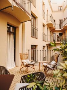 a patio with chairs and tables in front of a building at Hotel Casa Luz in Barcelona