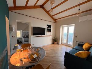 a living room with a table and a blue couch at Marilú vista mare con giardino in Genoa