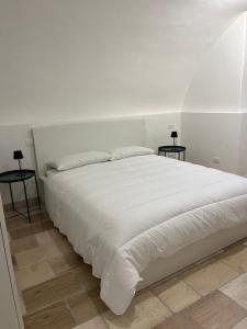 a white bed with two side tables in a bedroom at i GERMÅNI REALI in Scanno