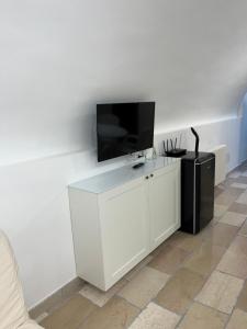 a living room with a tv on a white wall at i GERMÅNI REALI in Scanno