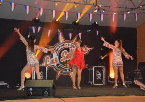 three women on a stage with their arms in the air at Camping Les Salisses - Aquatique Vacances in Vias