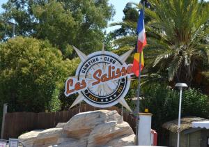 a sign for the las ssides with a flag at Camping Les Salisses - Aquatique Vacances in Vias