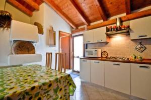 a kitchen with white cabinets and a table in a room at Su Ghindalu Guesthouse in Villanova Monteleone