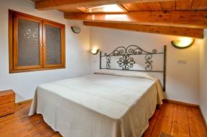 a bedroom with a white bed in a room at Su Ghindalu Guesthouse in Villanova Monteleone