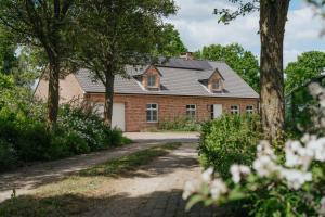 a brick house with a pathway in front at Vakantiewoning Pelterheggen in Grote Heide
