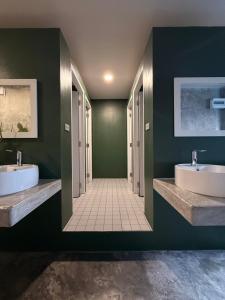 a bathroom with two sinks and green walls at Cheevit Cheeva Koh Tao Hostel in Ko Tao