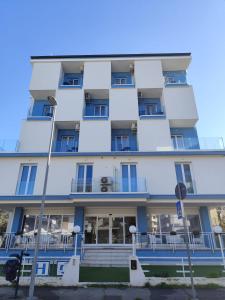 an apartment building with blue windows and steps at Gabbiano Suites in Cervia