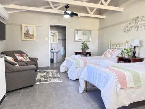 a bedroom with two beds and a couch and a couch at Sanctuary Guesthouse in Kimberley