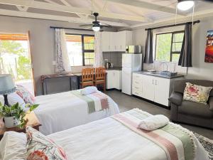 a bedroom with two beds and a kitchen at Sanctuary Guesthouse in Kimberley