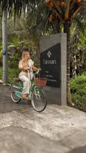 a woman riding a bike in front of a sign at Tannari Villa Ubud in Ubud +73 photos