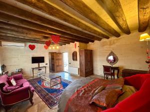 ein großes Wohnzimmer mit Sofa und Fernseher in der Unterkunft Avanos Suites in Avanos