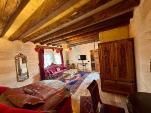 ein Wohnzimmer mit einer Couch und einem rosa Sessel in der Unterkunft Avanos Suites in Avanos + 21 Fotos