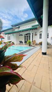 a house with a swimming pool in front of a building at Eco Villa Resort in Negombo