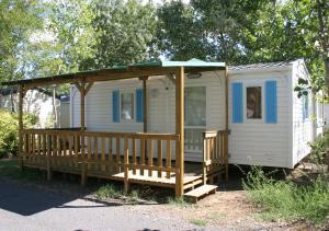 a white tiny house with a porch and a gazebo at Camping Les Salisses - Aquatique Vacances in Vias +6 photos