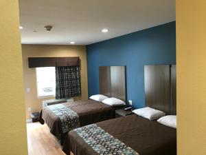 Postel nebo postele na pokoji v ubytování Deluxe Inn & Suites - Baytown