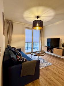 a living room with a blue couch and a tv at Apartament Perła Łagowa in Łagów