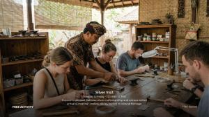 a group of people standing around a table at Sanctoo Suites & Villas in Gianyar
