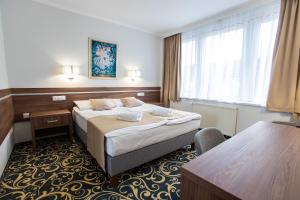 a hotel room with a bed and a window at Hotel Árpád in Tatabánya +48 photos
