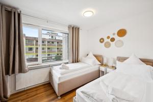 a bedroom with two beds and a window at Ramoni Apartments - Abendgold in Enzklösterle