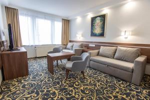 a hotel room with two couches and a television at Hotel Árpád in Tatabánya
