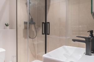 a bathroom with a shower and a white sink at Le Chic, en hypercentre au calme in Limoges +25 photos