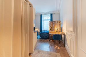 a room with a desk and a bedroom with a bed at Le Chic, en hypercentre au calme in Limoges