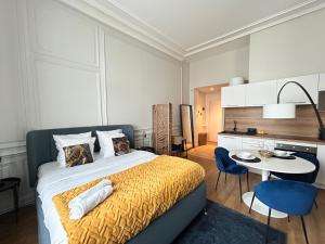 a bedroom with a large bed and a table and chairs at Le Chic, en hypercentre au calme in Limoges