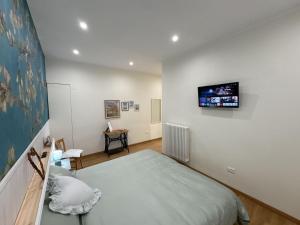 a bedroom with a bed and a tv on the wall at Le Jardin Fleuri in Castelluccio Valmaggiore