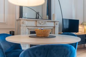 a table with blue chairs and a basket on it at Le Chic, en hypercentre au calme in Limoges